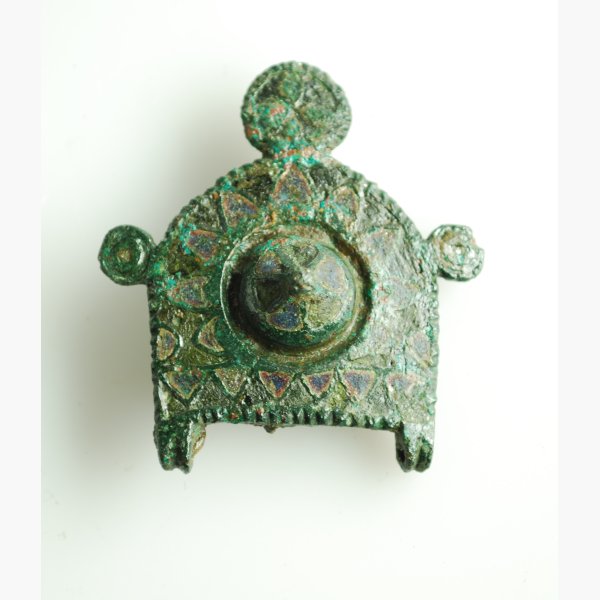 The brooch has enamelled triangles on the front